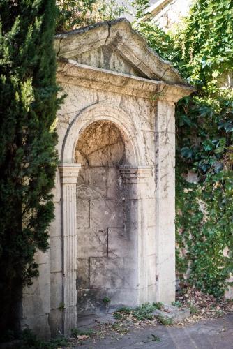 an archway in a stone wall with a tree at Hotel d'Angleterre in Avignon