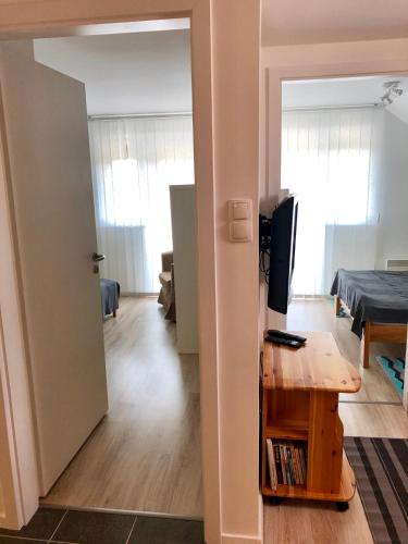 a living room with a desk and a television at Geri Apartman in Mezőkövesd