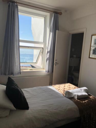 a bedroom with a bed with a large window at Edelweiss Guest House in Douglas