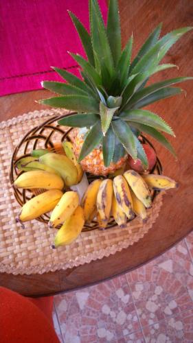 a basket of bananas and a pineapple on a table at Villa Victoria in Trou dʼ Eau Douce