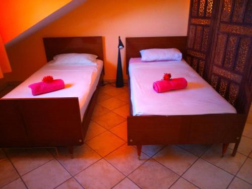2 camas con almohadas rojas en una habitación en Villa Victoria, en Trou d'Eau Douce