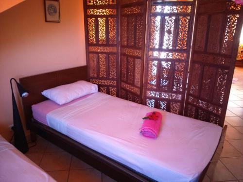 a room with a bed with a pink bag on it at Villa Victoria in Trou dʼ Eau Douce