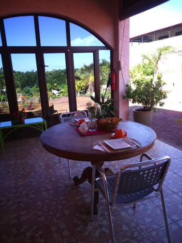 a table and chairs in a room with a large window at Villa Victoria in Trou dʼ Eau Douce