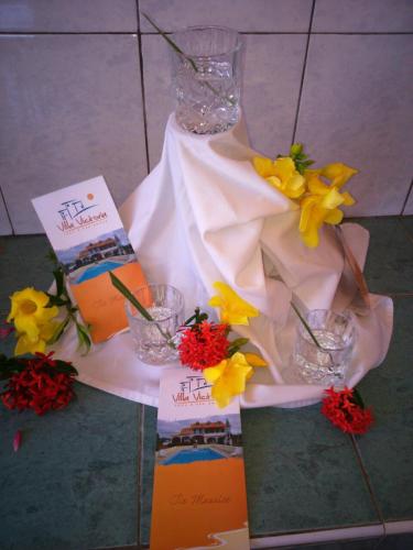 a table topped with vases and flowers and cards at Villa Victoria in Trou dʼ Eau Douce