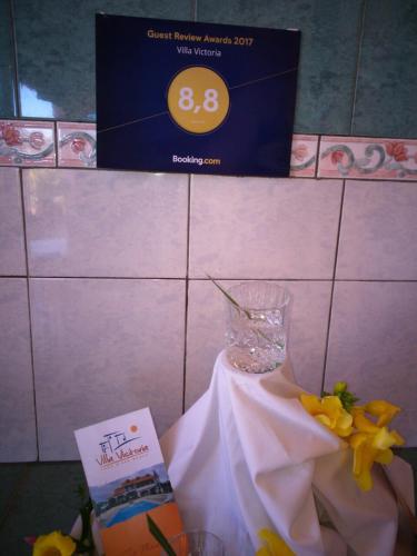 a table topped with a vase with flowers and a card at Villa Victoria in Trou dʼ Eau Douce