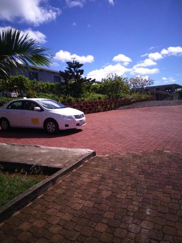 a white car parked on a brick driveway at Villa Victoria in Trou dʼ Eau Douce