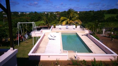 a large swimming pool with a slide and a swimming pool at Villa Victoria in Trou dʼ Eau Douce