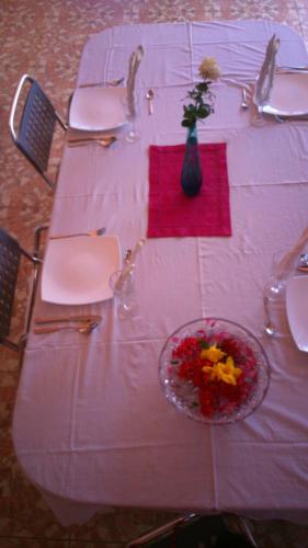 a white table with a vase of flowers on it at Villa Victoria in Trou dʼ Eau Douce