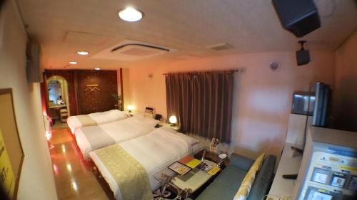 a bedroom with a large bed and a couch at Hotel Vegas (Adult Only) in Sapporo