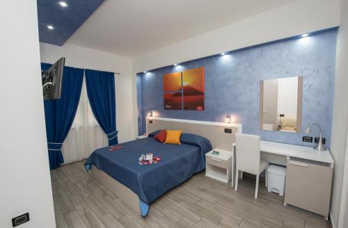 a bedroom with a blue bed and a desk at B&B Sunlight Tropea in Tropea