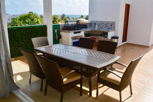 a dining room table and chairs with a view of the ocean at Suites SanRey in Puerto Morelos