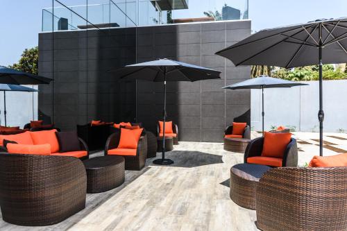 an outdoor seating area with orange chairs and umbrellas at Ceiba Hotel Bissau in Bissau