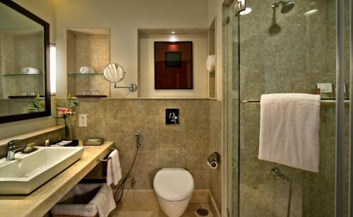 a bathroom with a toilet and a sink and a shower at Fortune Park JPS Grand Rajkot - Member ITC Hotels' Group in Rajkot