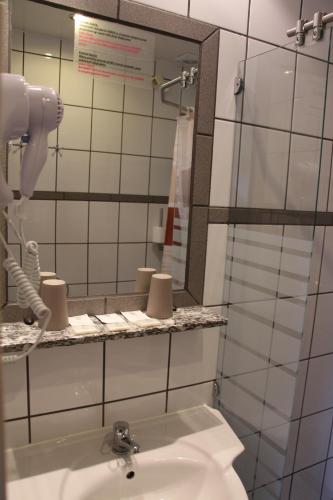 a bathroom with a sink and a mirror at Avila Park & SPA in Dziwnówek