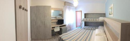 a small room with two bunk beds and a kitchen at La Coccinella Residence in San Vincenzo