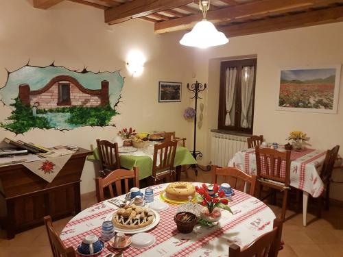 a dining room with tables and chairs and a painting on the wall at B&B Antica Fonte del Latte in Santa Vittoria in Matenano