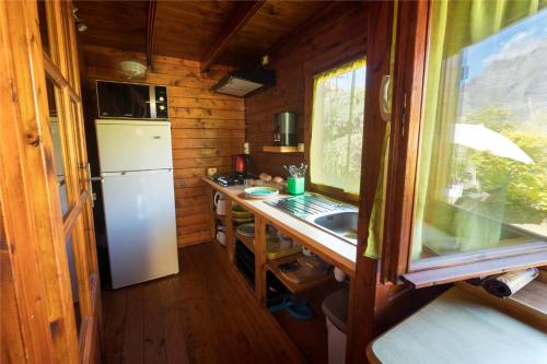 una pequeña cocina con fregadero y nevera. en La Cabane du Raideur en Cilaos
