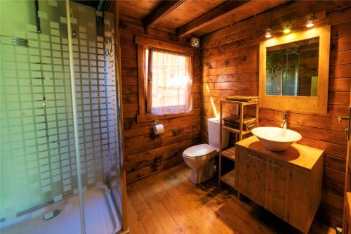baño de madera con lavabo y aseo en La Cabane du Raideur, en Cilaos
