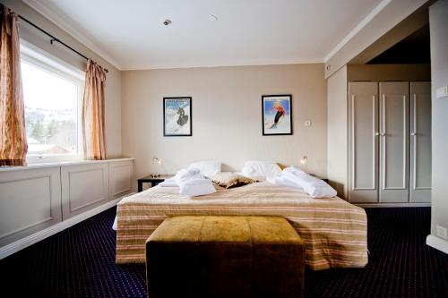 a bedroom with a large bed and a window at Skogstad Hotel - Unike Hoteller in Hemsedal
