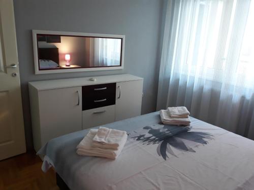 a bedroom with a bed with two towels on it at Apartment Azzuro 2 in Novi Sad