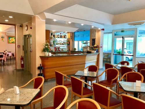 a restaurant with tables and chairs and a bar at Hotel Blue Ribbon in Rimini