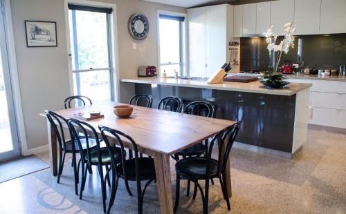 a kitchen with a wooden table and chairs at Corrugated Cottage in Dunkeld