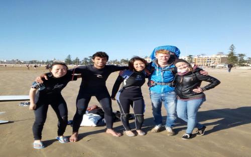 a group of people posing for a picture on the beach at White And Blue in Essaouira