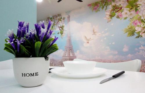 a vase of flowers on a table with the eiffel tower at H2H - Nichole Maison - Majestic Ipoh in Ipoh