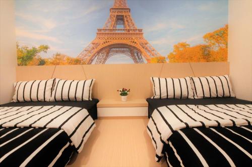 two beds in a room with the eiffel tower at H2H - Nichole Maison - Majestic Ipoh in Ipoh
