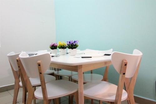 a dining room table with chairs and flowers on it at H2H - Nichole Maison - Majestic Ipoh in Ipoh
