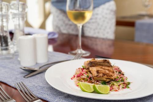 a white plate with a sandwich and a glass of wine at Nungwi Dreams by Mantis in Nungwi
