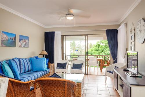 a living room with a blue couch and a balcony at La Pirogue 19 in Ballito