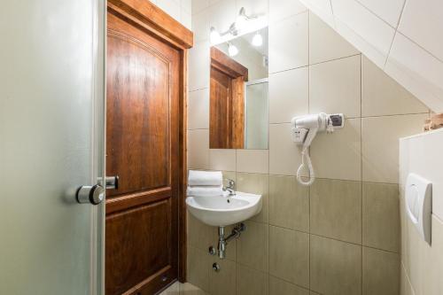 a bathroom with a sink and a mirror at Willa Baciarka-basen, sauny i jacuzzi in Kościelisko