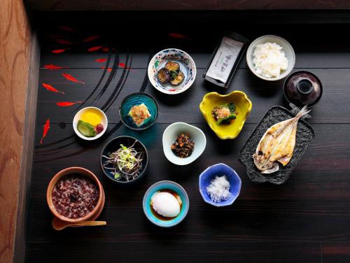 a table topped with bowls of food and other foods at Goyokan in Izu