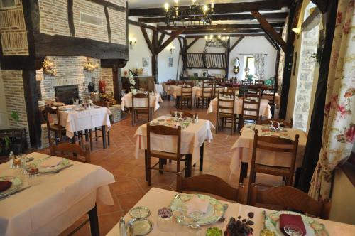 a dining room with tables and chairs in a restaurant at Logis Hotels - Auberge de l'Île - Hôtel 3 étoiles et Restaurant in Creysse