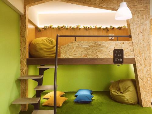 a bunk bed in a room with green walls at Green Hotel - Fengjia in Taichung