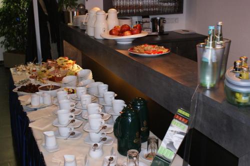 a buffet line with cups and plates of food at Hotel im Kornspeicher in Marburg an der Lahn