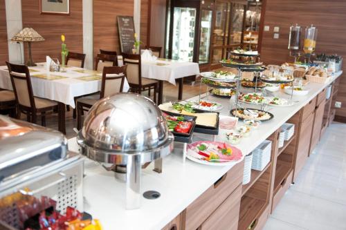 a buffet line with plates of food in a restaurant at Hotel Rad in Grudziądz