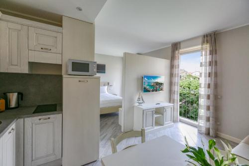 a small white kitchen with a bed and a window at San Lorenzo Apartments in Sirmione