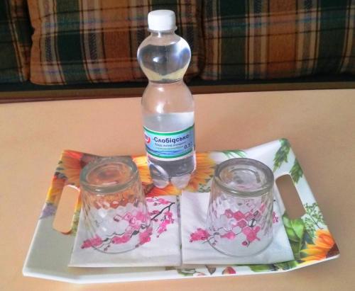 a bottle of water sitting on a tray with two jars at Inter Hotel in Ternopilʼ