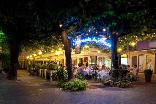 a restaurant with people sitting at tables outside at night at San Lorenzo Apartments in Sirmione