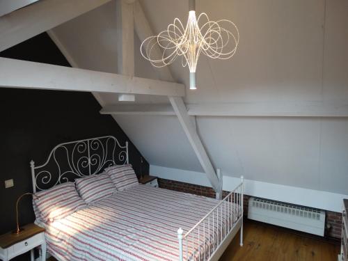 a bedroom with a bed and a chandelier at Huyze Peerdenbrugghe in Bruges