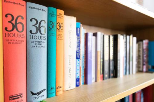 a row of books on a book shelf at Former Rembrandt workshop two bedroom B&B in Amsterdam