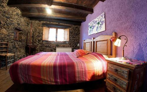 - une chambre en pierre avec un grand lit dans l'établissement Casa Independiente Rural Ca de Corral, à Taull