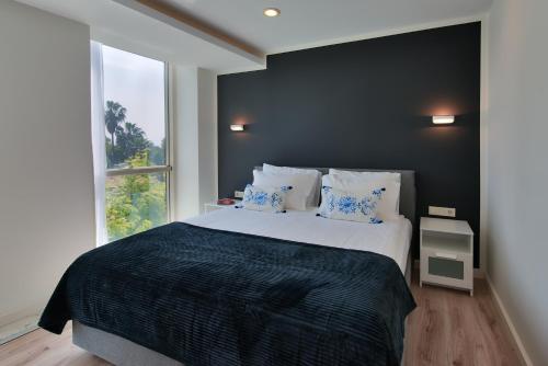 1 dormitorio con 1 cama grande y ventana grande en Arkk Homes en Antalya
