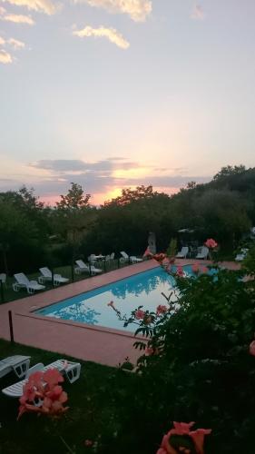 vista para uma piscina ao pôr-do-sol em Locanda Delle Noci em Perugia