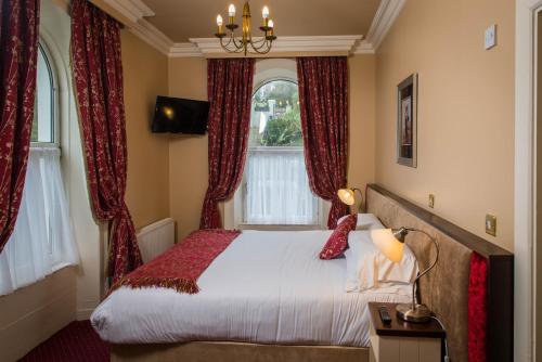 a bedroom with a large bed with red curtains at Gabriel House Guesthouse in Cork