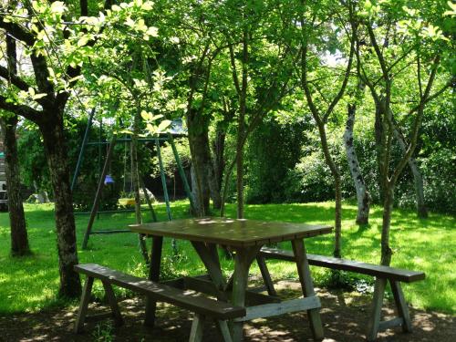 a picnic table and bench in a park with a swing at Chambres d'Hôtes de la Ferme Auberge de Mésauboin in Billé