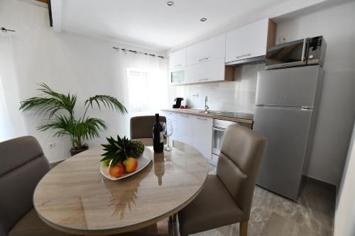 a kitchen with a table with a bowl of fruit on it at Apartment Lavanda in Sinj