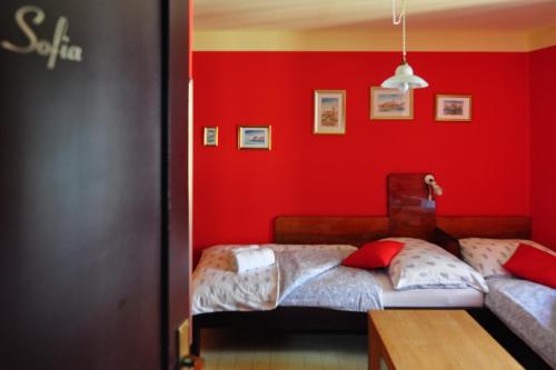 ein rotes Schlafzimmer mit 2 Betten und einem Tisch in der Unterkunft Max Piran in Piran
